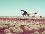 1975 : Cessna 182P Skylane (VH-DXC) chartered from Transwest Air Charter Pty Ltd., Kalgoorlie, used for Spot photography of level traverse bench marks and some trig stations in the Great Sandy and Gibson Deserts. VH-DXC is seen here landing at Kidson Field.