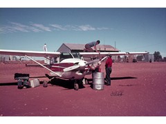 1970 TG100 Ground marking, WA Jayrow Helicopters chartered Cessna used for crew change ex Alice Springs at Warburton Mission, unknown on wing, Dave King, Jayrow Engineer, standing.